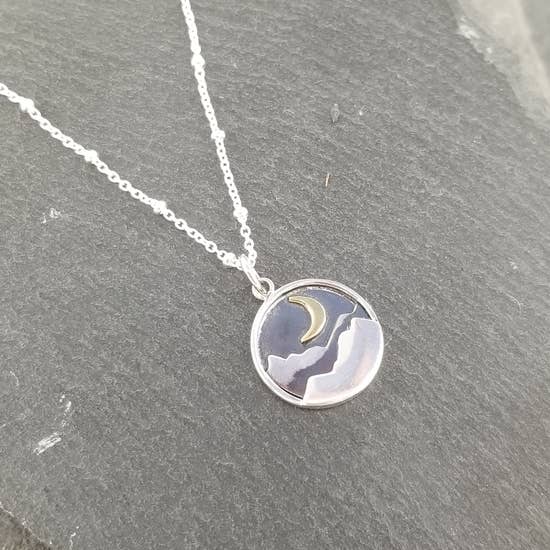 Crescent moon above mountain on circle necklace